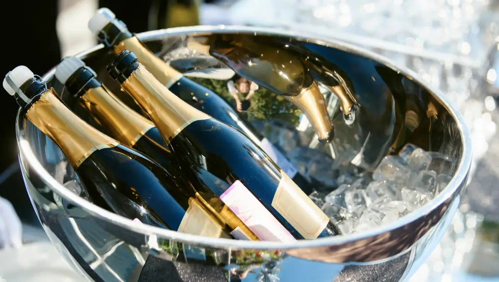 Image of a bottle of champagne in an ice bucket and two glasses nearby