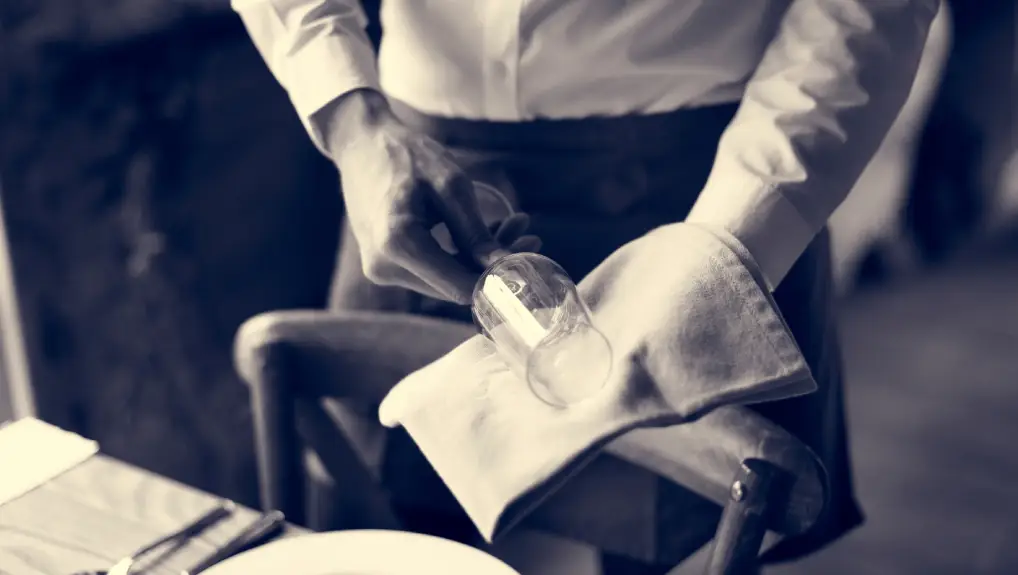 image of hospitality staff handling glassware in a restaurant setting