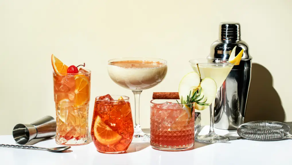 image of essential bar equipment in bar setting with a yellow background