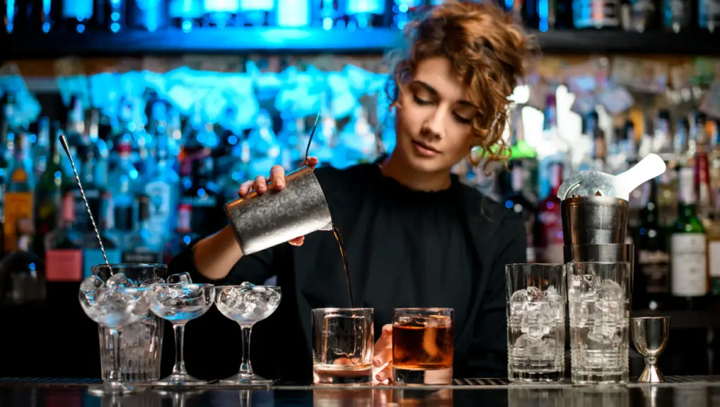 image of a bartender using must have bar tools ideal for beginners in a pro bar setting.