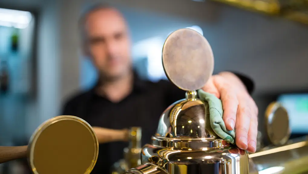 close up of bartender cleaning bar pump after reading the bar equipment maintenance cleaning and care tips