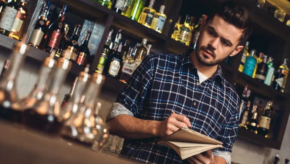 image of a bartender looking over his professional bartenders checklist