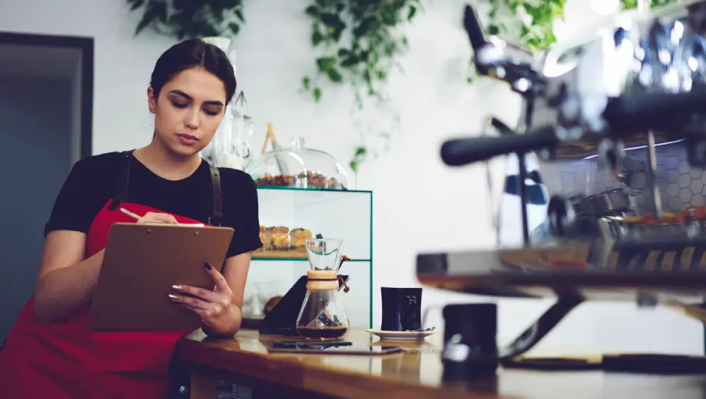 Image of a bartender checking bar equipment in a restaurant setting