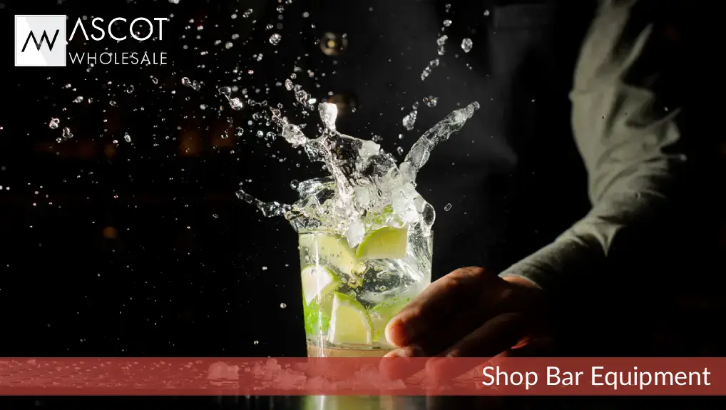 close up image of ice cubes cut with bar tools splashing in a cocktail glass in a bar