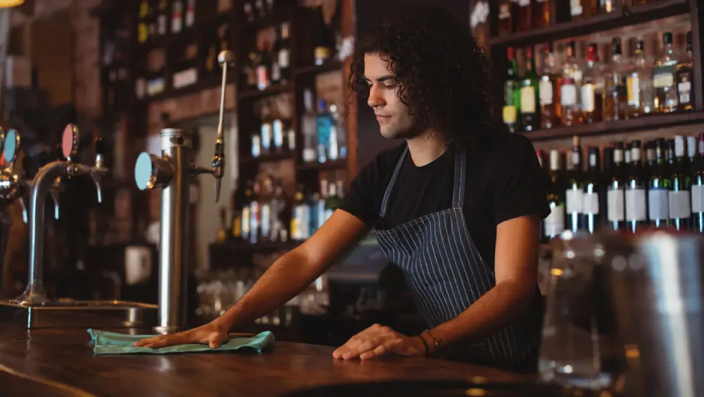 Image of a bar with a bartender displaying how to maintain your bar equipment for a longer life