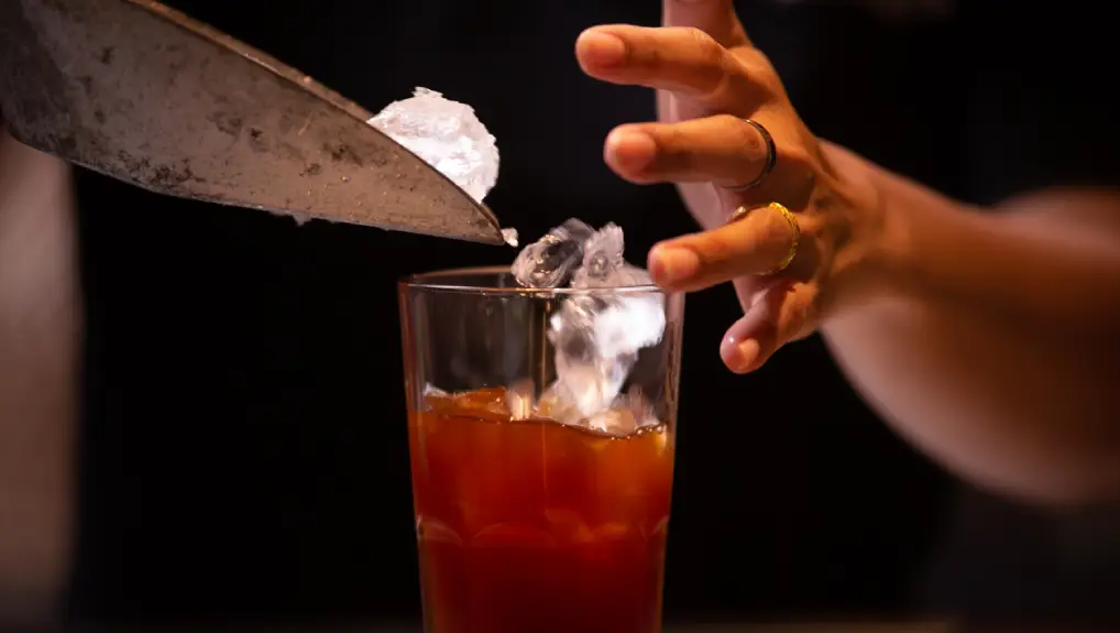Close up image of a bartender using ice tool essentials