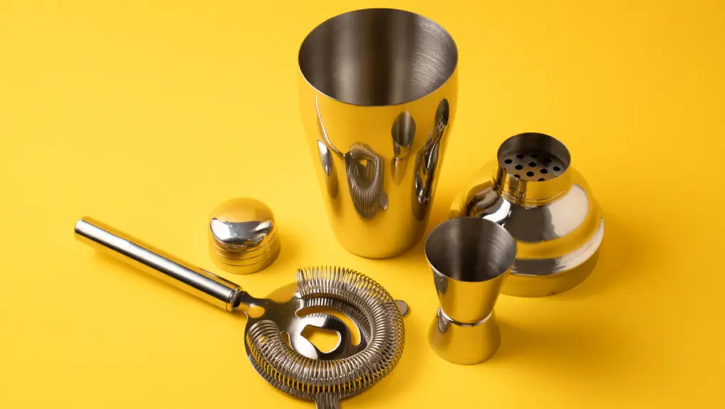Close up studio shot of a Cobbler shaker with a yellow background. The Best Cocktail Shaker for Beginners: Boston, Cobbler, or French?