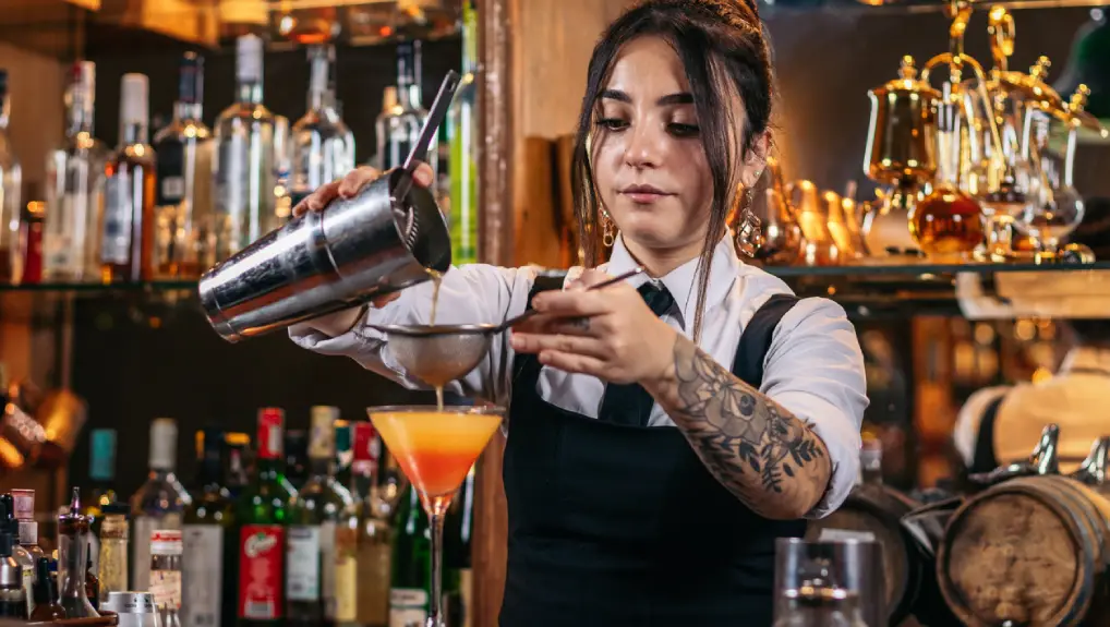 Close up of a bartender using the best cocktail tools for new mixologists skills