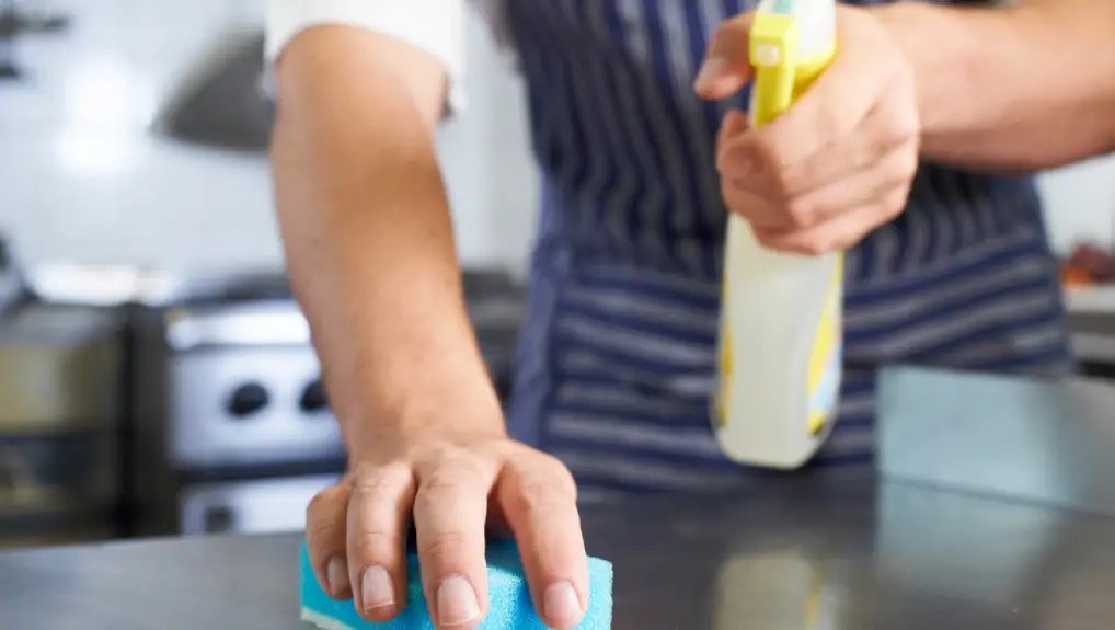 Image of a member of bar staff using cleaning products for cleaning bar equipment