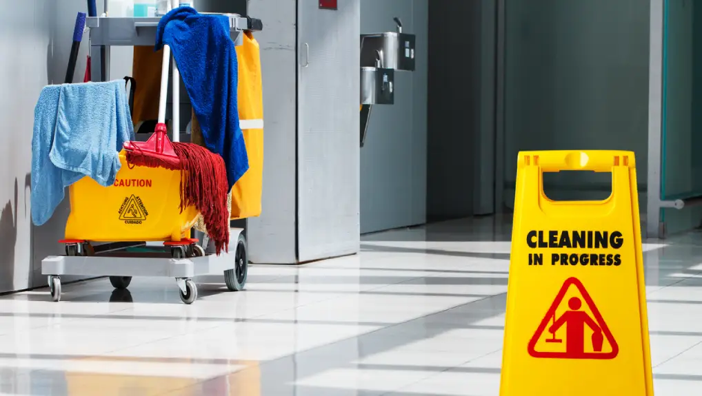 Close up image of a set of top cleaning products for cleaning bar equipment and a caution cleaning in progress sign.