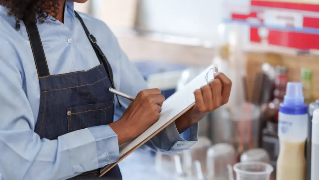 close up image of a bartender using a daily checklist for bar tools and equipment.