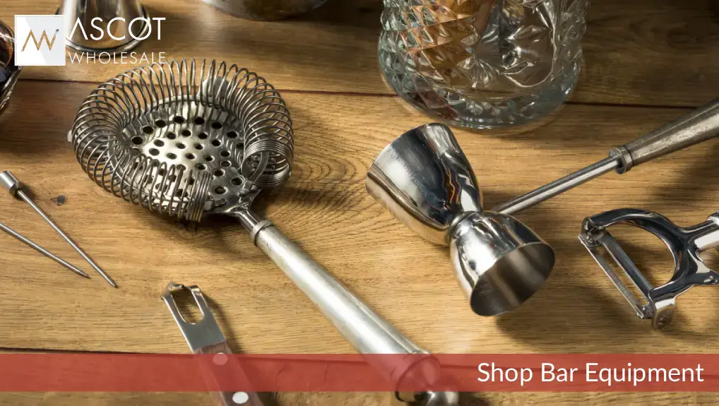 Close up image of the best cocktail tools for a mixologist including Hawthorne strainer, double-sided jigger