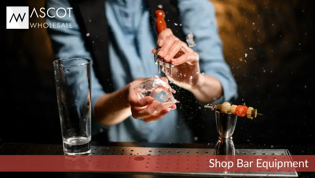 Close up image of a bartender using ice tools in a small commercial bar.