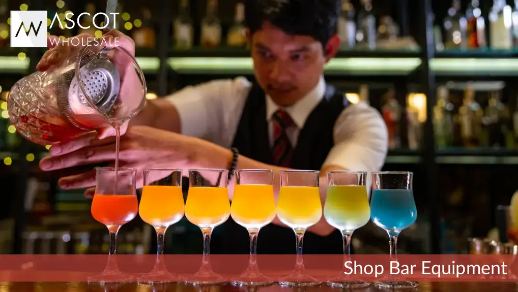 Bartender pouring colourful drinks using bar equipment