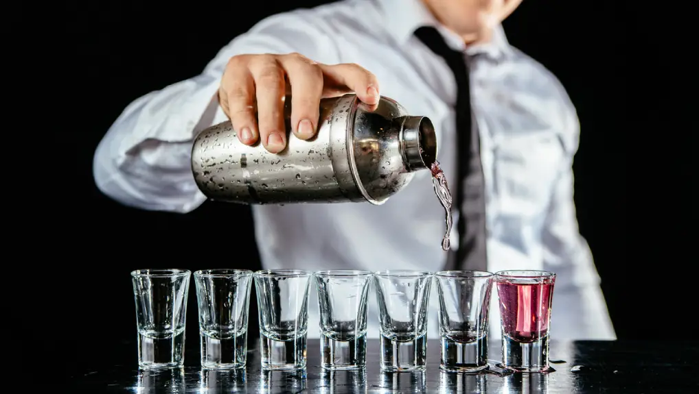 Professional bar tender pouring shots at a bar