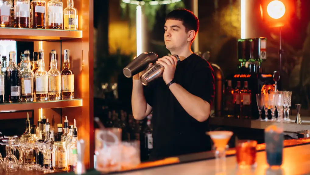 image of a bartender mixing drinks at a cocktail bar