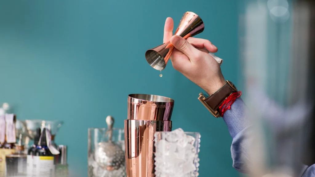 bartender prepares a great cocktail using jigger