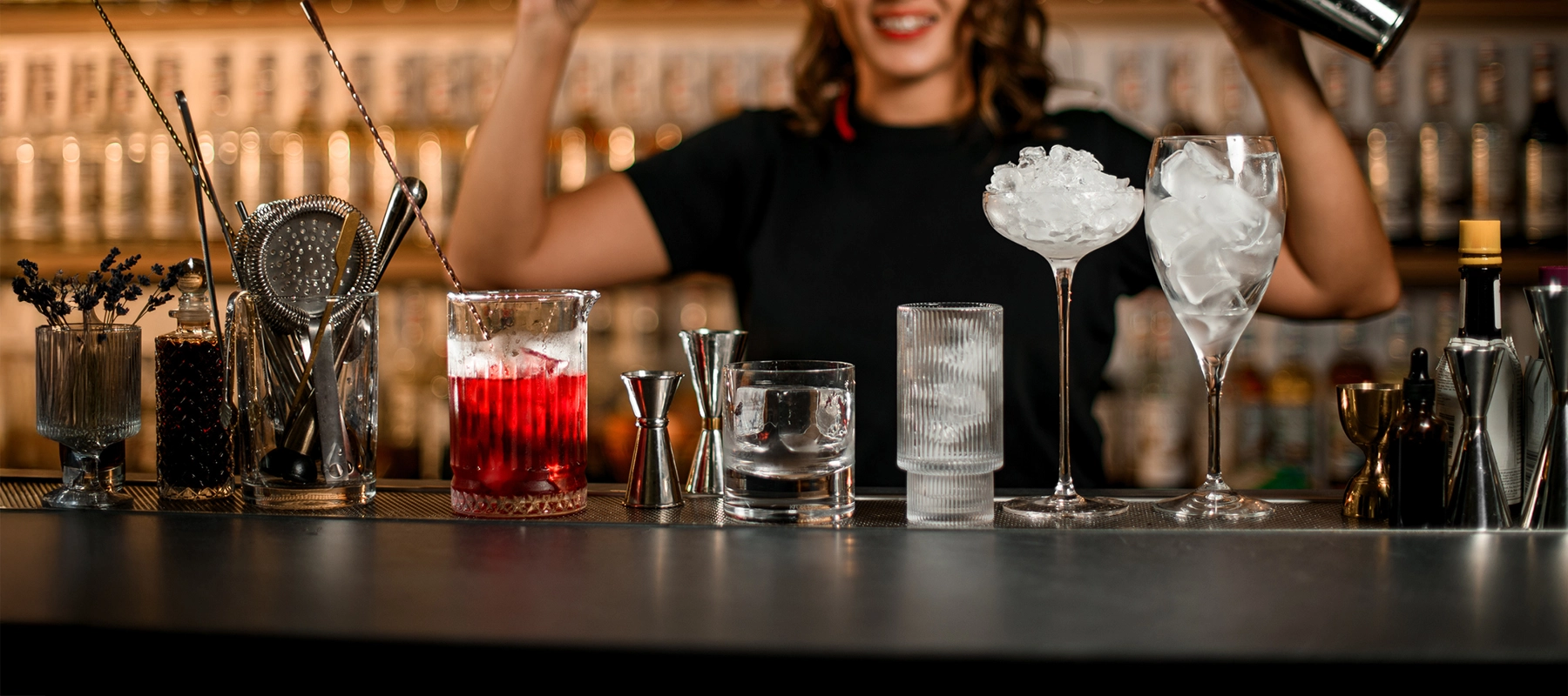 An image of a woman with a plethora of cocktail tools