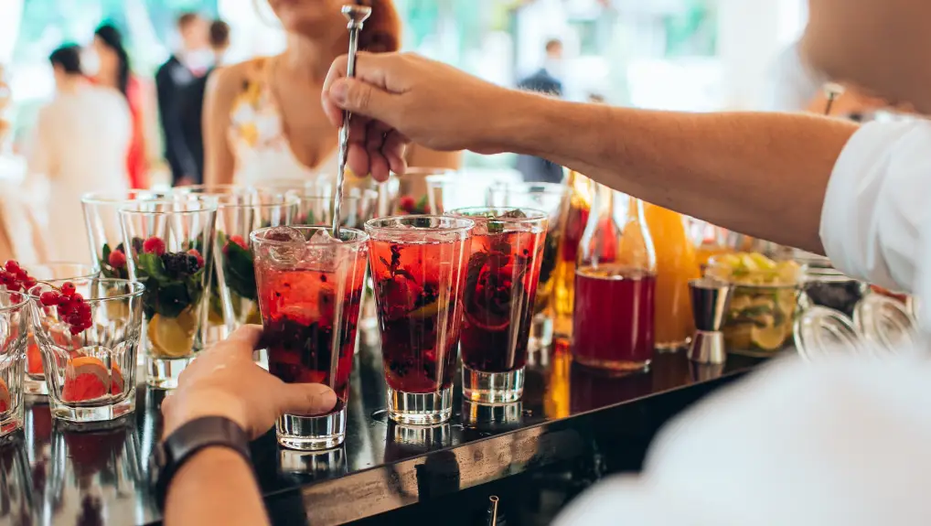 Hand making red cocktail at the open-air wedding party.

