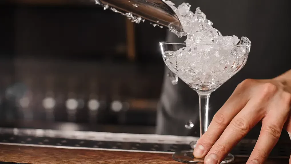 An image of crushed ice being scooped into a cocktail glass using sustainable ice equipment