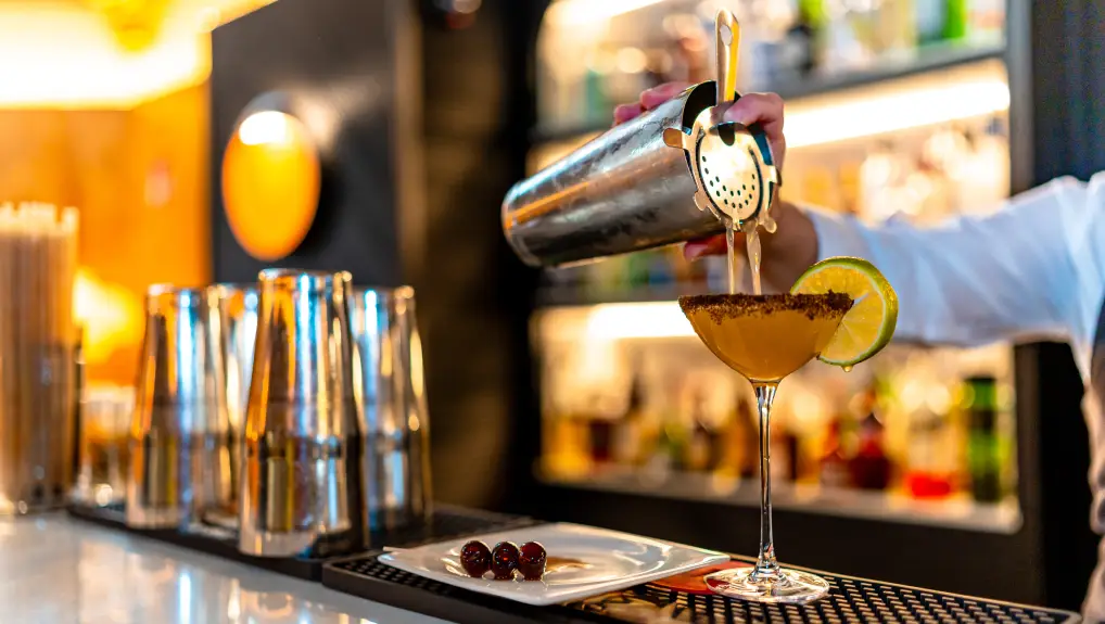 an image of a bar with a mixologist crafting a cocktail