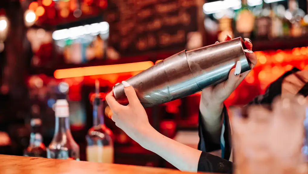image of a cocktail shaker being used at a bar