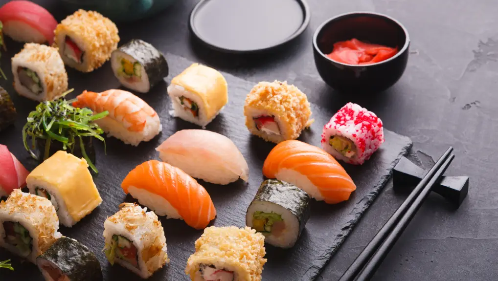 image of sushi and rolls background, on black, top view