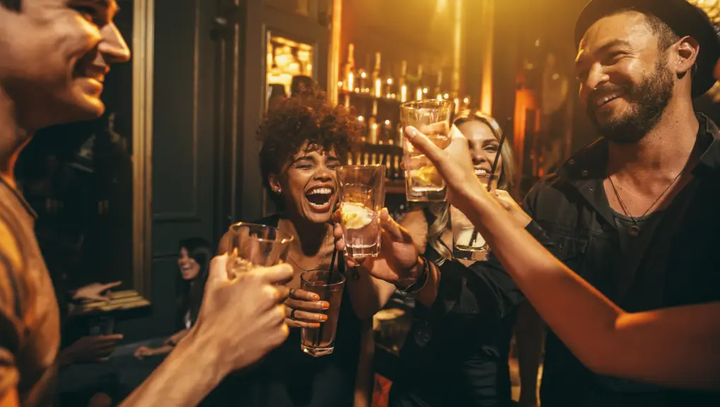 Image of men and women enjoying a party. Group of friends having drinks at a cocktail bar