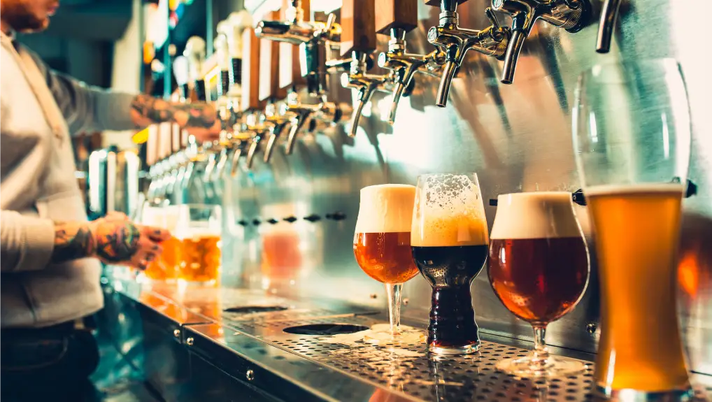 Image of and of bartender pouring a large lager beer in tap in a commercial bar