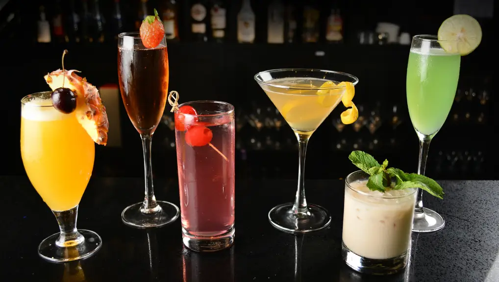 Image of bartender make special cold cocktail or mocktail in tall glass goblet