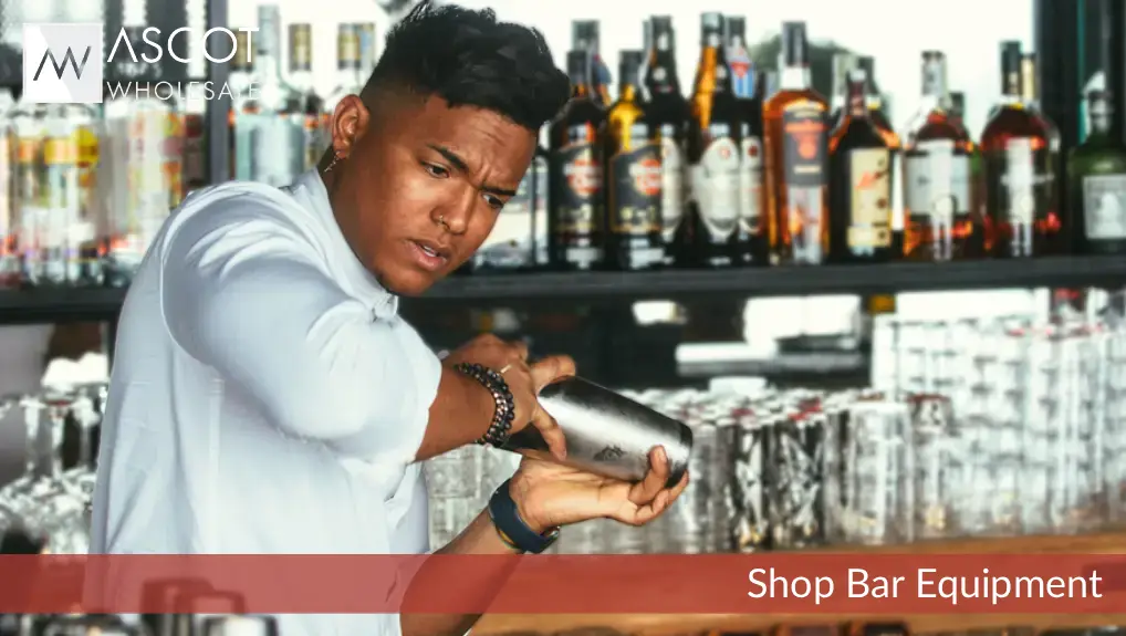 male expert barman is shaking a shaker for preparation of a cocktail at the bar counter- shows bar tools history