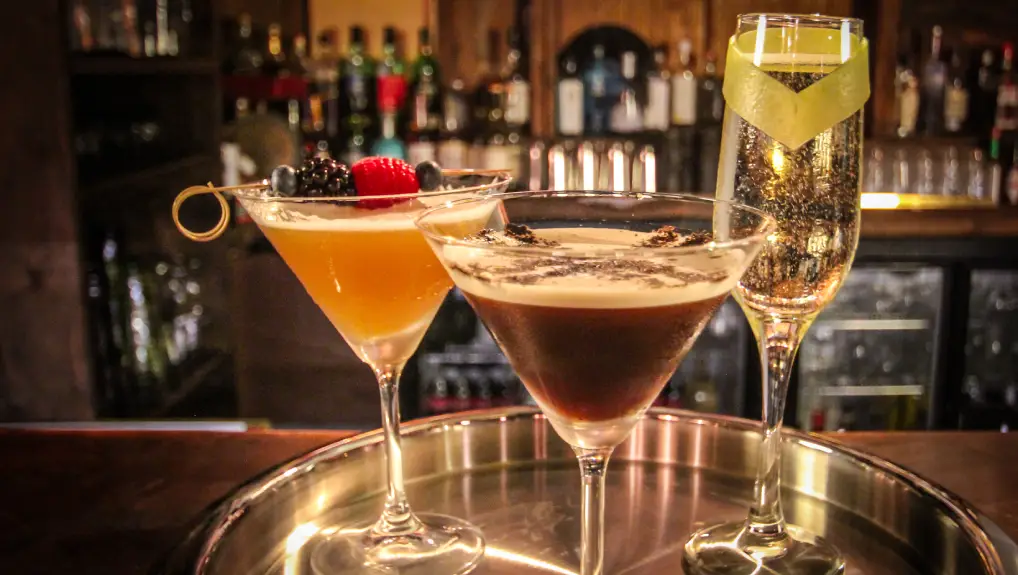 Image of 3 drinks glasses on a serving tray with garnish - Unique Design Elements- custom glassware for bars