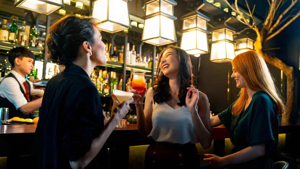 Group of Attractive woman enjoy and fun hangout nightlife meeting and drinking fancy cocktail together at luxury bar. Happy female friends celebrating holiday event party at nightclub in the city
