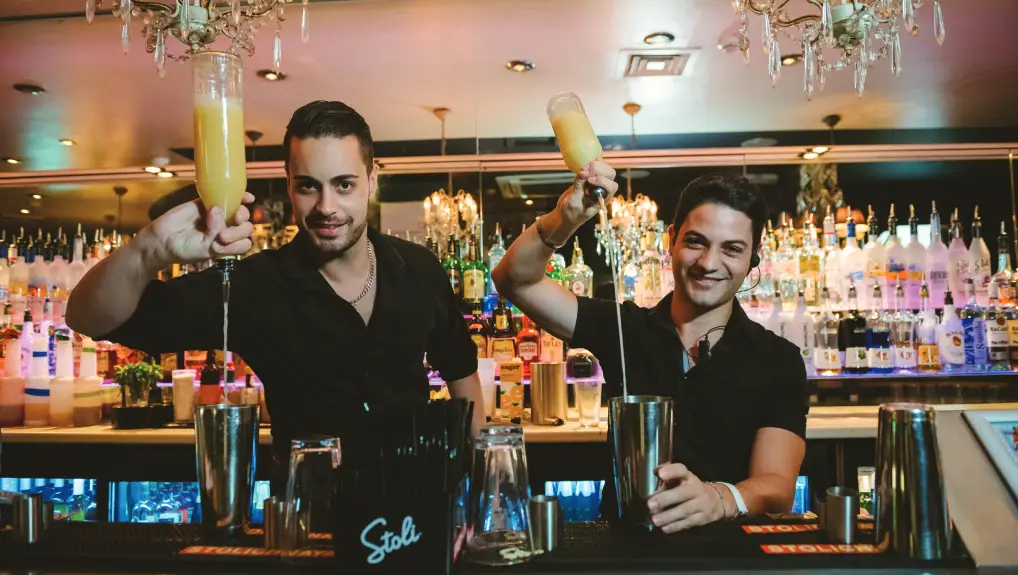 Image of bartenders serving and mixing drinks behind the bar- By Beaumont