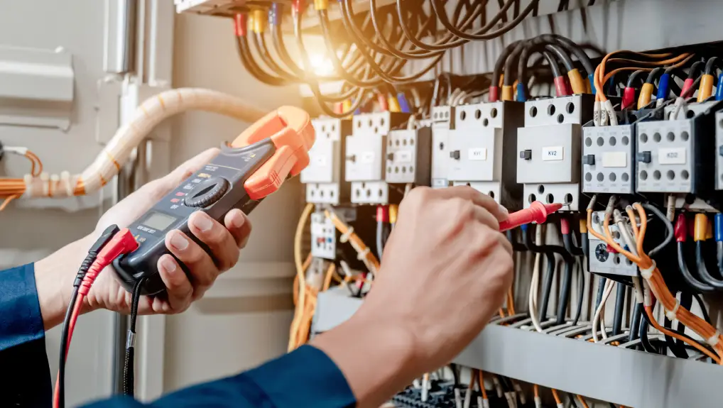 Image of Electrician engineer uses a multimeter to test the electrical installatio