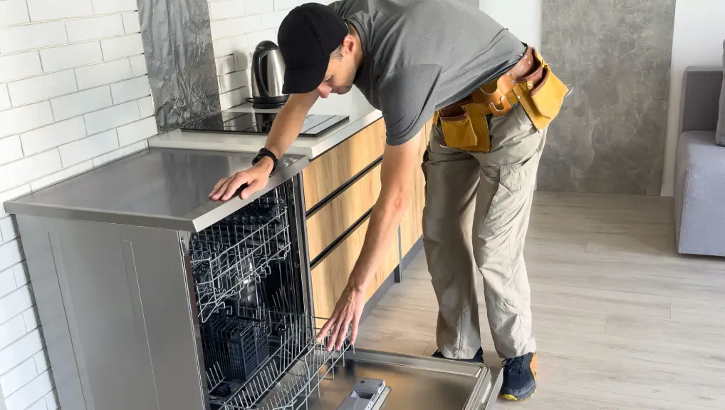 Young Repairman Service Worker Repairing Dishwasher Appliance- Catering Equipment Maintenance UK