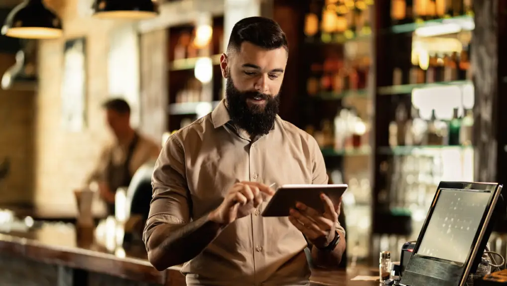 waiter using touchpad while working in a pub- technology innovation