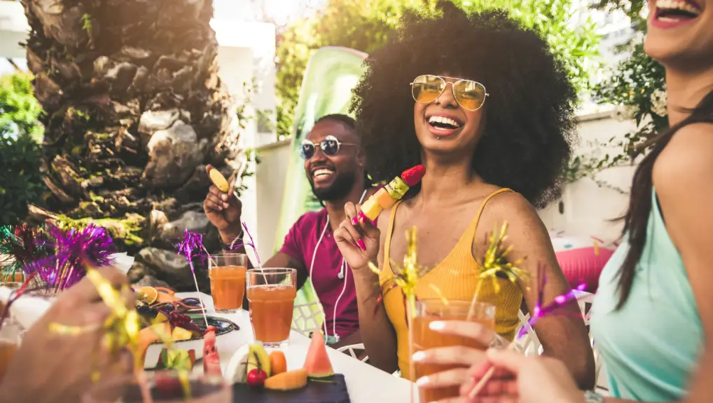 Image of Happy woman smiling at the camera having fun with friends outdoor at her home bar- garden bar accessories ideas