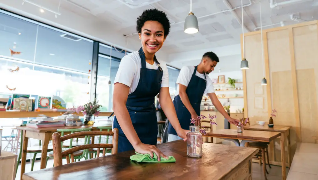 Image of waiter cleaning restaurant with sanitation products- restaurant disposable supplies checklist