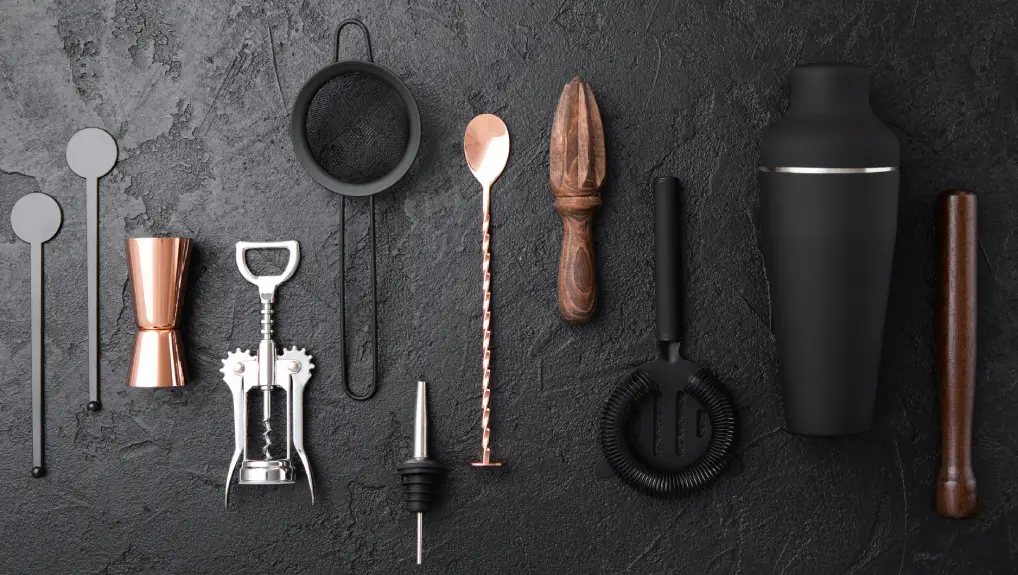Strainer,shaker,jigger,straw,manual juicer,wooden muddler,wine opener on black stone background with copper bar spoon.
gift ideas unique bar accessories