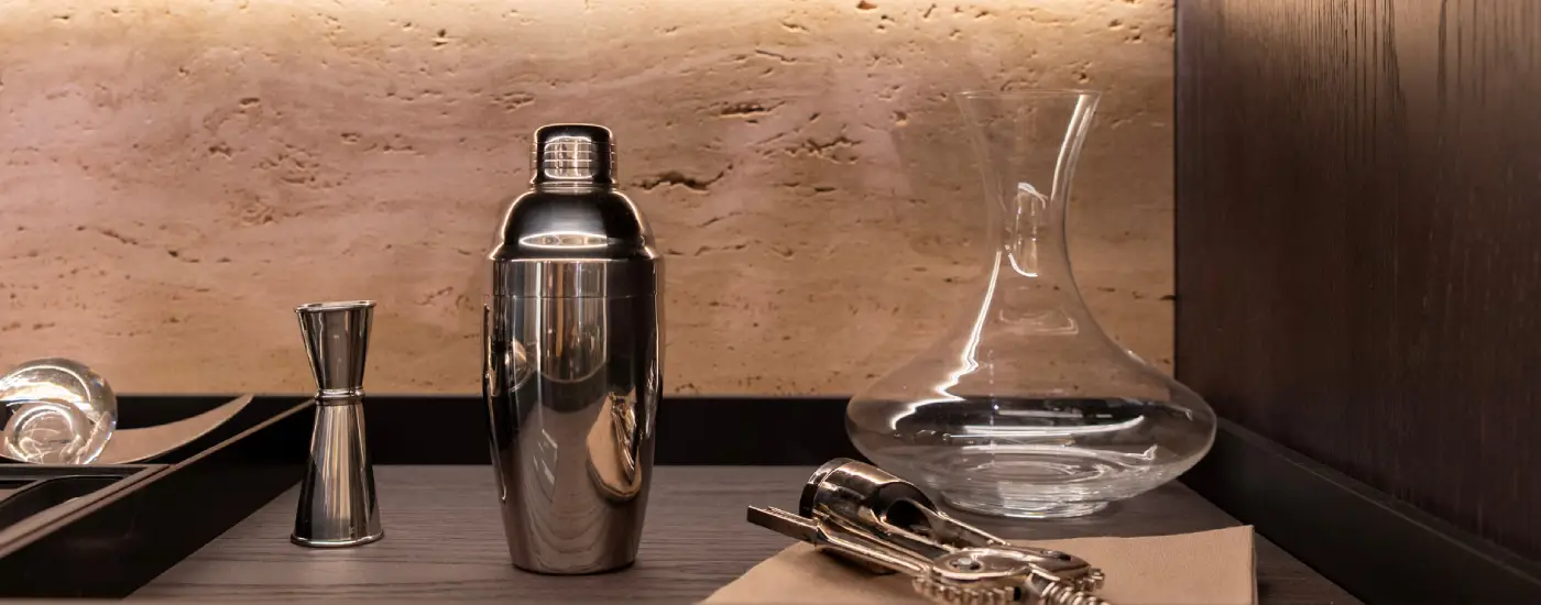 image of Stainless cocktail shaker with jigger and glass decanter on shelf
