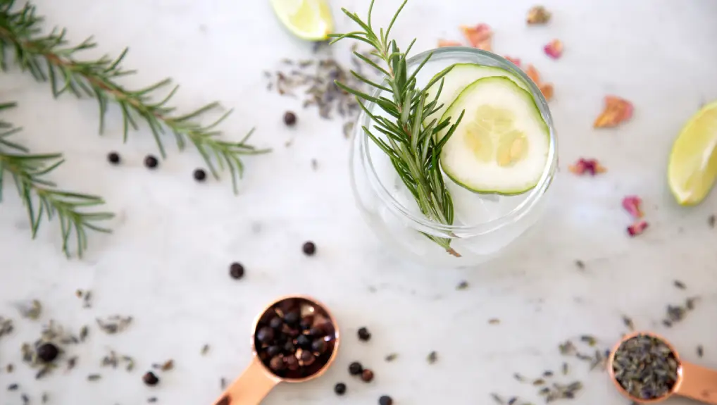 Cocktails on marble table top with spices and garnishes- custom barware design guide
